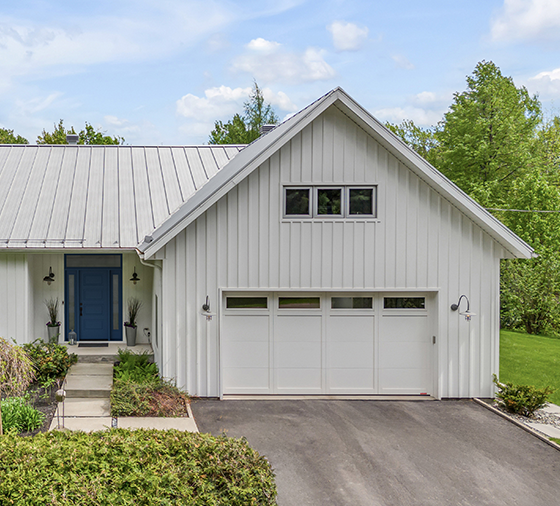 Garaga residential garage door in Ice White with the E-11 design, matching overlays and windows.