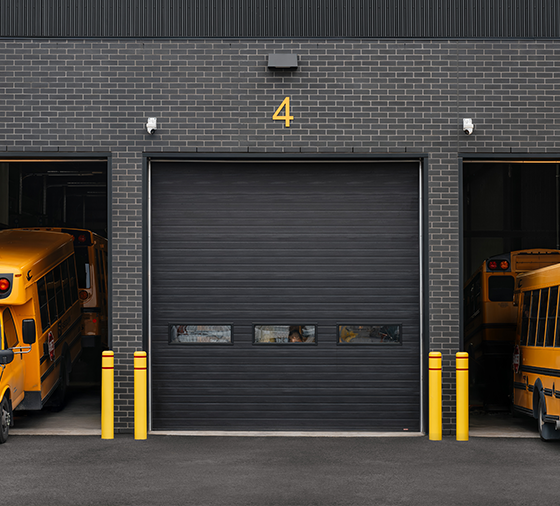 Garaga G-5000 commercial garage doors in Black, 14' x 14', Grooved design, Long windows and Uniform woodgrain steel.