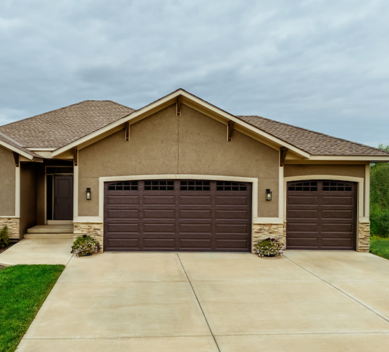Garaga residential garage door in Brown with the Long Panel design and Stockton and Double Stockton Arch window inserts.