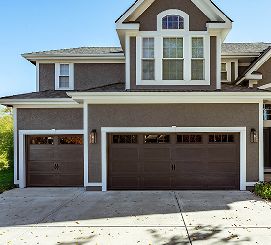 Garaga residential garage door in Brown with the Recessed Long design and Richmond window inserts.