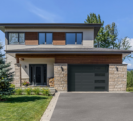 Garaga residential garage door in Iron Ore with the Shaker-Modern XL design and Harmony windows with Black Satin glass.