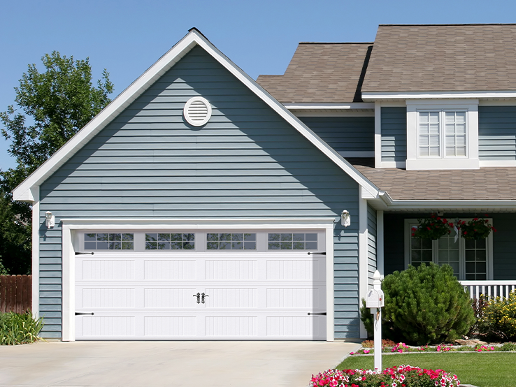 Garaga residential garage door in White with the Beadboard Long design and Stockton Long window inserts.