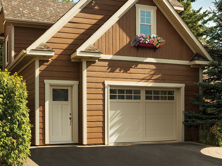 Garaga residential garage door in Desert Sand with the E-11 design, matching overlays and Panoramic windows.