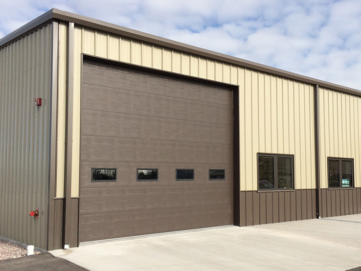Garaga 16' x 14' commercial garage door in Brown with the Flush design, windows and Uniform woodgrain steel.