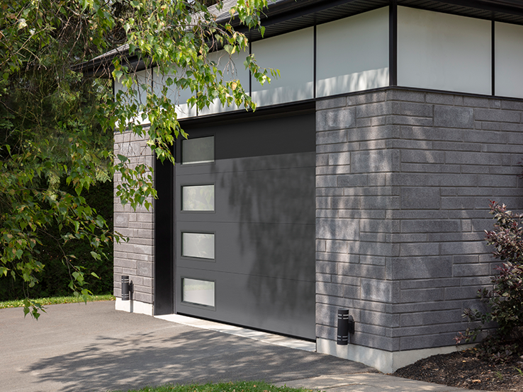 Garaga residential garage door in Charcoal with the Flush design and left-side Harmony windows.