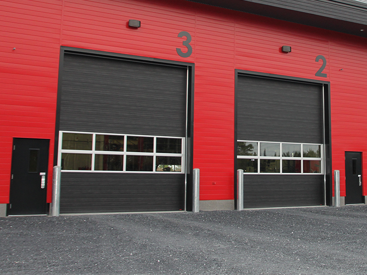 Garaga G-5000 commercial garage doors in Black, 14' x 16', Grooved design, Full-view window sections and Uniform woodgrain steel.