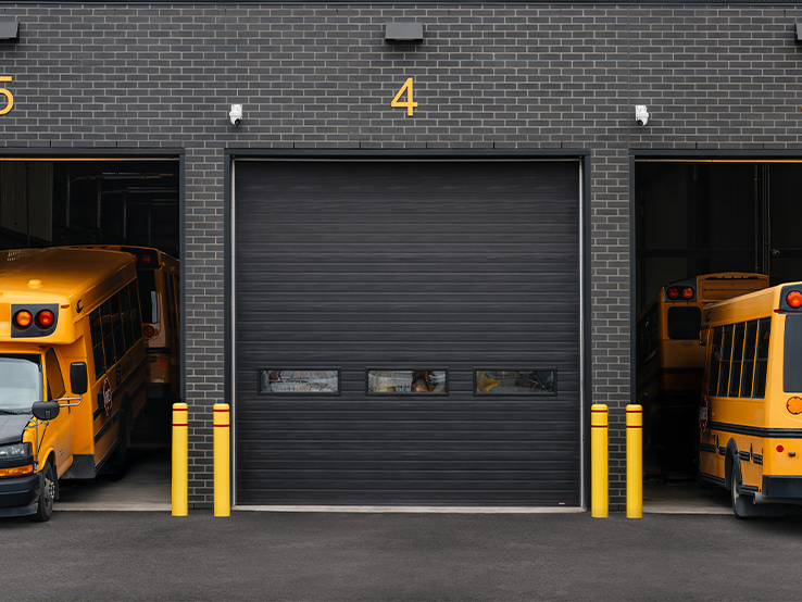 Garaga G-5000 commercial garage doors in Black, 14' x 14', Grooved design, Long windows and Uniform woodgrain steel.