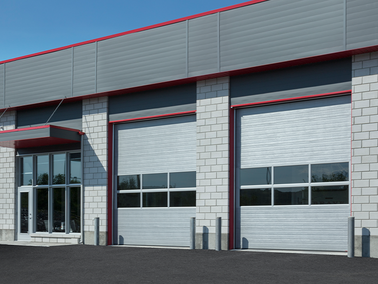Garaga G-5000 commercial garage doors in Silver, 12' x 14', Grooved design, Full-view window sections and Uniform woodgrain steel.