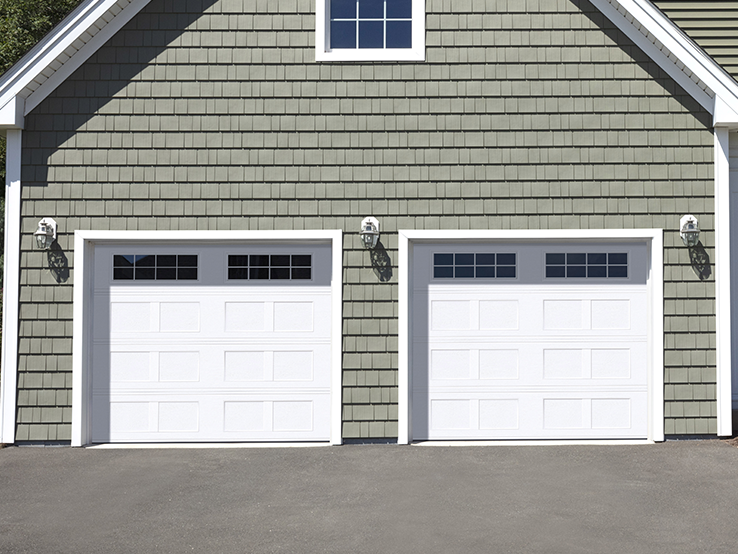 Garaga residential garage door in White with the I1 design, a recessed base and Stockton window inserts.