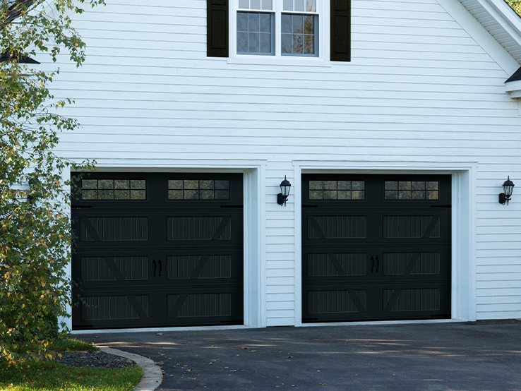 Garaga residential garage door in Black Ice with the V design, a beadboard base and Stockton window inserts.