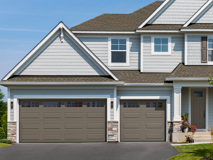 Garaga residential garage door in Terrastone with the Classic Long design and Stockton window inserts.