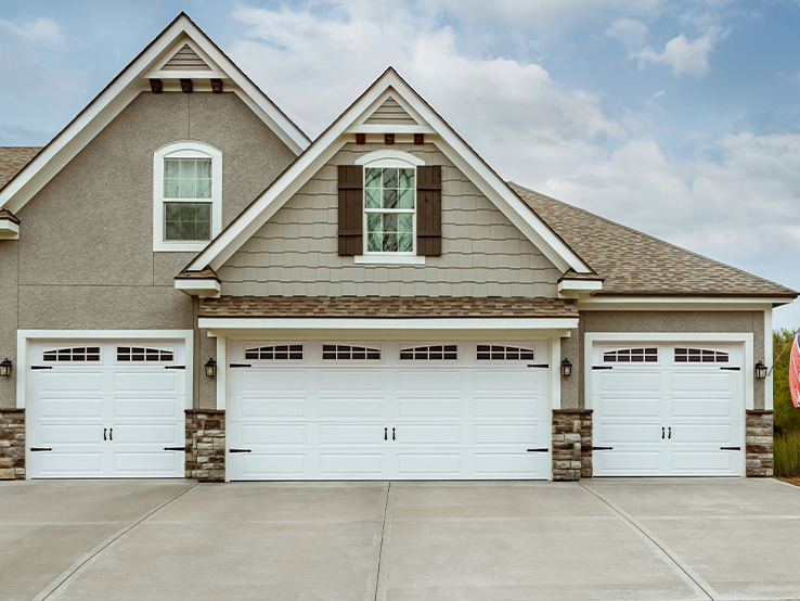 Garaga residential garage door in White with the Long Panel design and Double Stockton Arch window inserts.