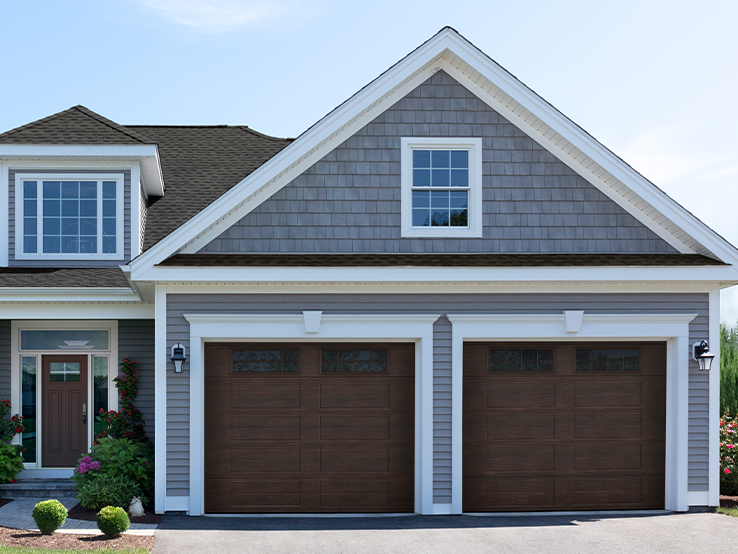 Garaga residential garage door with a Dark Walnut faux-wood finish, the Louver Two Slat design and Stockton window inserts.