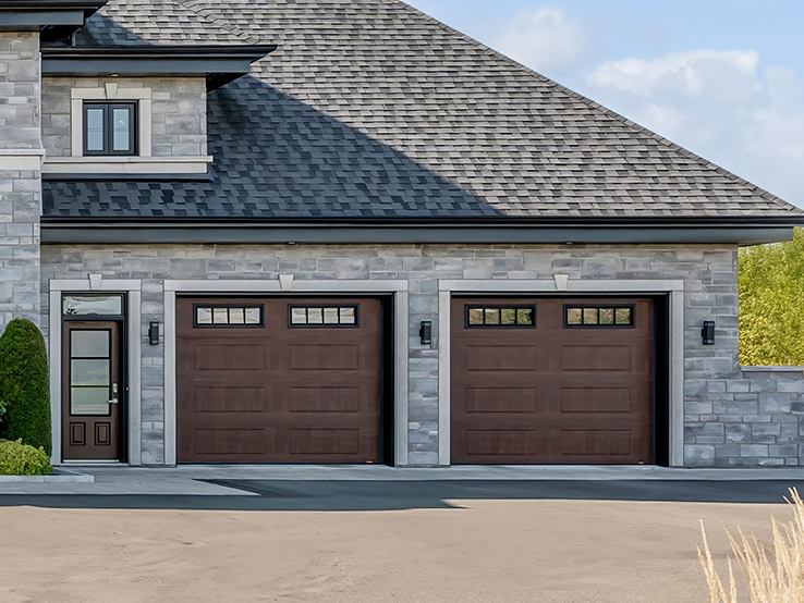 Garaga residential garage door with a American Walnut faux-wood finish, the North Hatley LP design and Richmond window inserts.