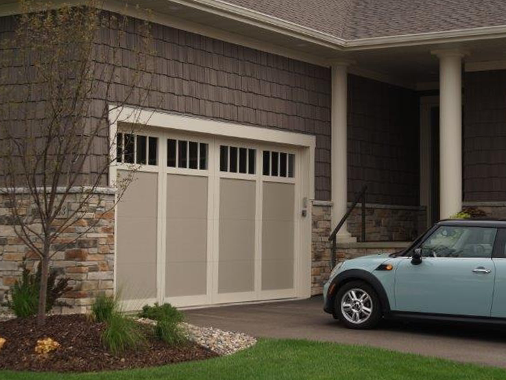 Garaga residential garage door in Sandstone with the I0 design, White overlays and Richmond windows.