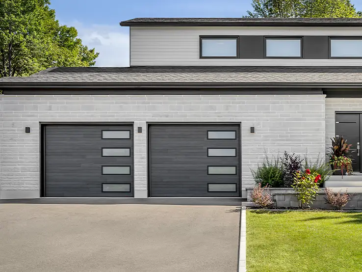 Garaga residential garage door with a Carbon Oak HD faux-wood finish, the Plank design and Right-side Harmony windows.