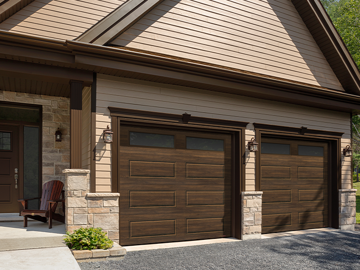 Garaga residential garage door with a Chocolate Walnut faux-wood finish, the Prestige XL design and Pinhead glass.