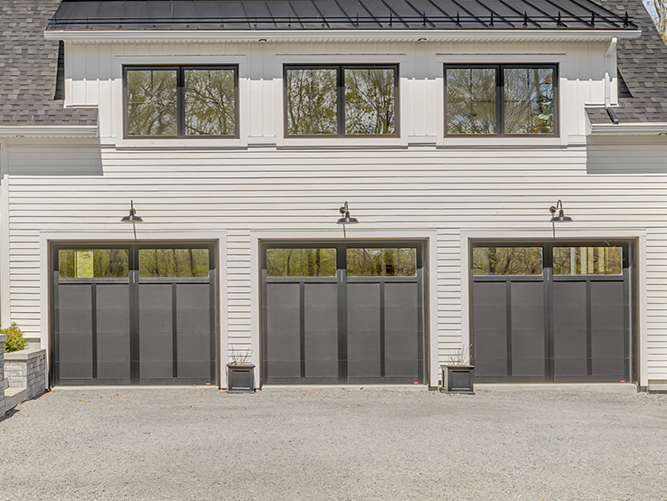 Garaga residential garage door in Black with the P-12 design, matching overlays and Panoramic windows.