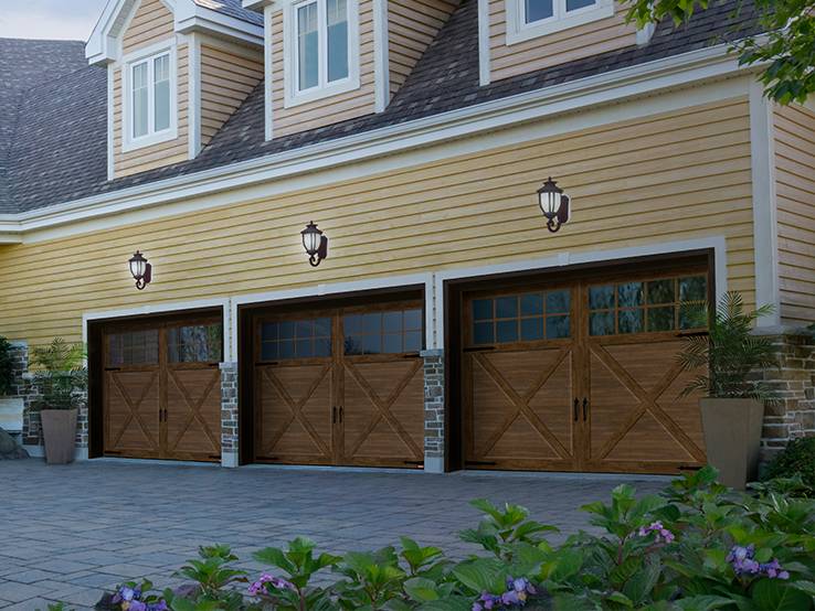 Garaga residential garage door with a Chocolate Walnut faux-wood finish, the P-21 design, matching overlays and Panoramic windows.
