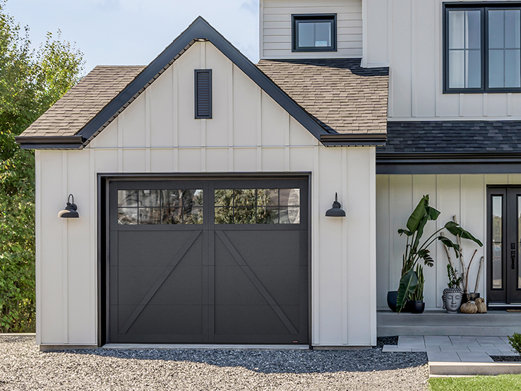 Garaga residential garage door in Black with the P-22 design, matching overlays and Panoramic windows.