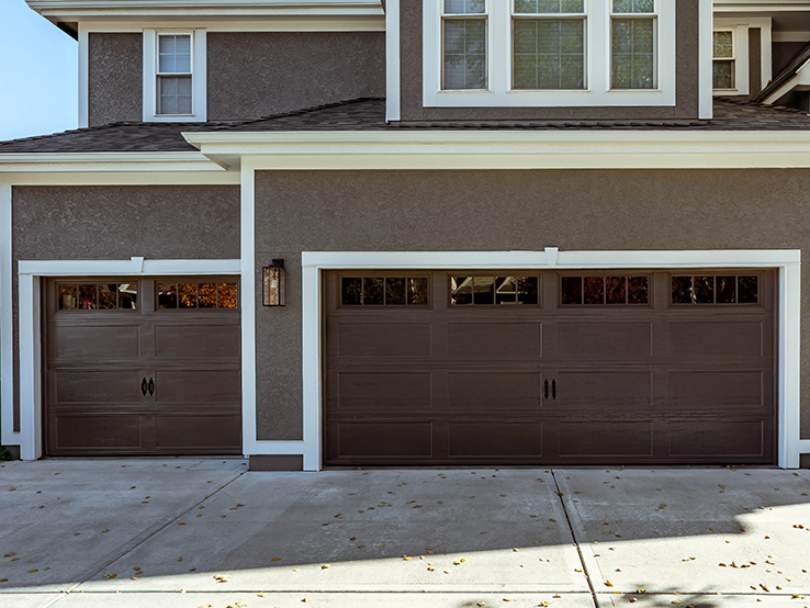 Garaga residential garage door in Brown with the Recessed Long design and Richmond window inserts.