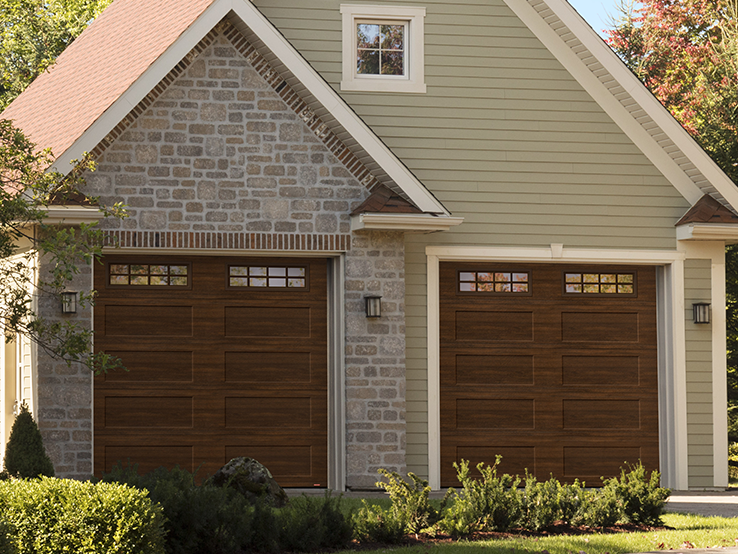 Garaga residential garage door with a Chocolate Walnut faux-wood finish, the Shaker-Flat XL design and Stockton window inserts.