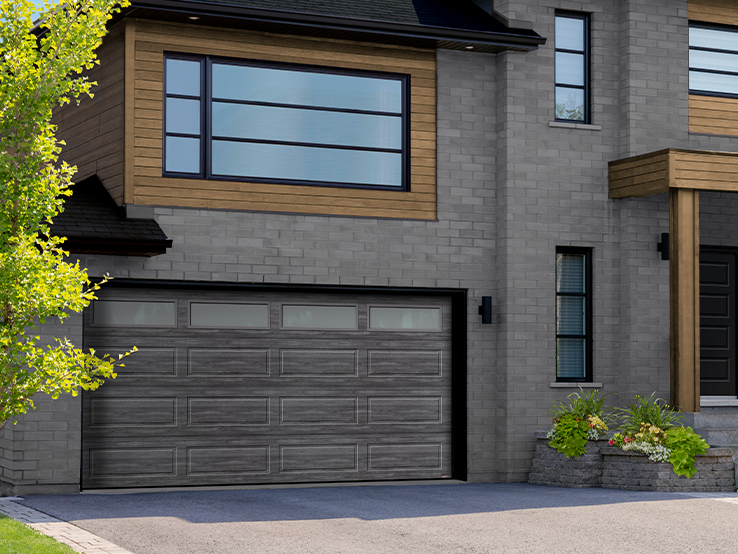 Garaga residential garage door with a Weathered Grey faux-wood finish, the Shaker-Modern XL design and windows.