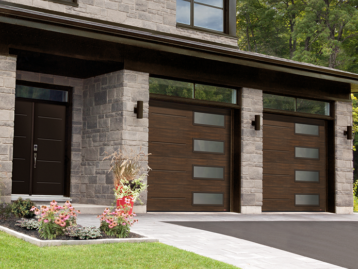 Garaga residential garage door with a Chocolate Walnut faux-wood finish, the Vogue design and Right-side Harmony windows.
