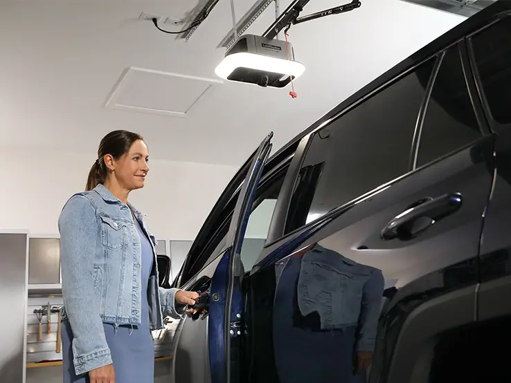 Femme utilisant l'application myQ depuis sa voiture avec le LiftMaster 6690L.