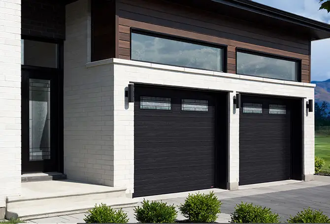 Modern contemporary transitional style stone house with light brown wood inserts featuring 2 Black insulated garage doors with Cachet Stained Glass windows