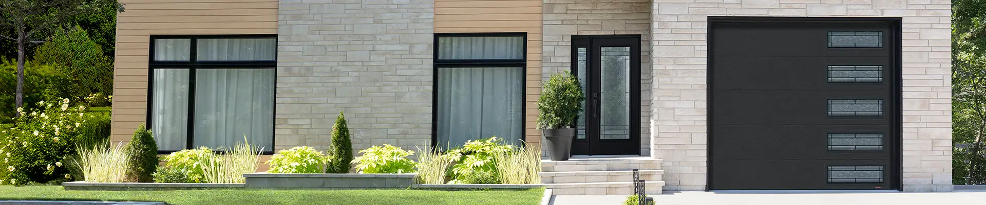 Modern home with a sleek black flush garage door featuring windows with Celeste glass.