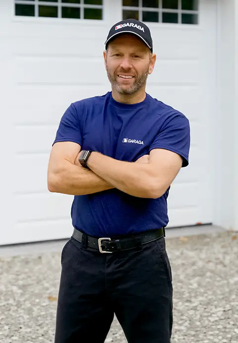 A technician standing in front of a garage door
