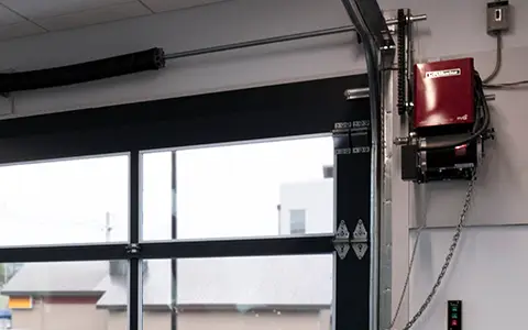Commercial garage interior with a fully glassed garage door and a LiftMaster commercial door opener.