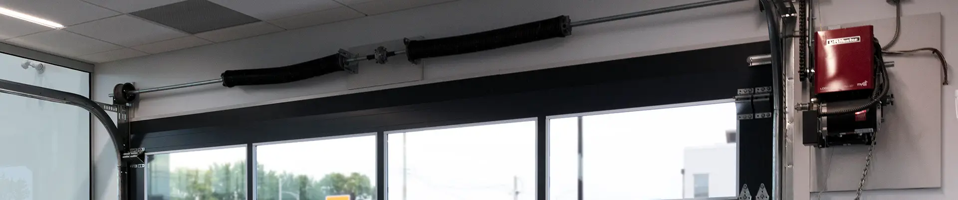 Commercial garage interior with a fully glassed garage door and a LiftMaster commercial door opener.